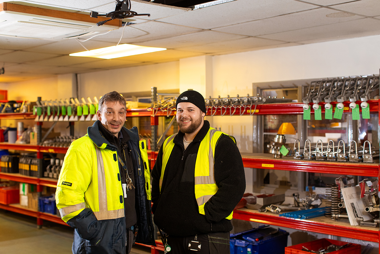 A manager and apprentice having a meeting at a table with a laptop. 