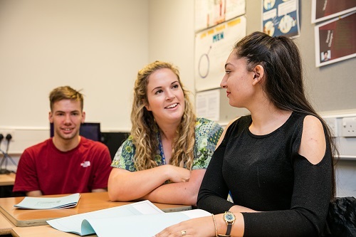 Students and teacher around table