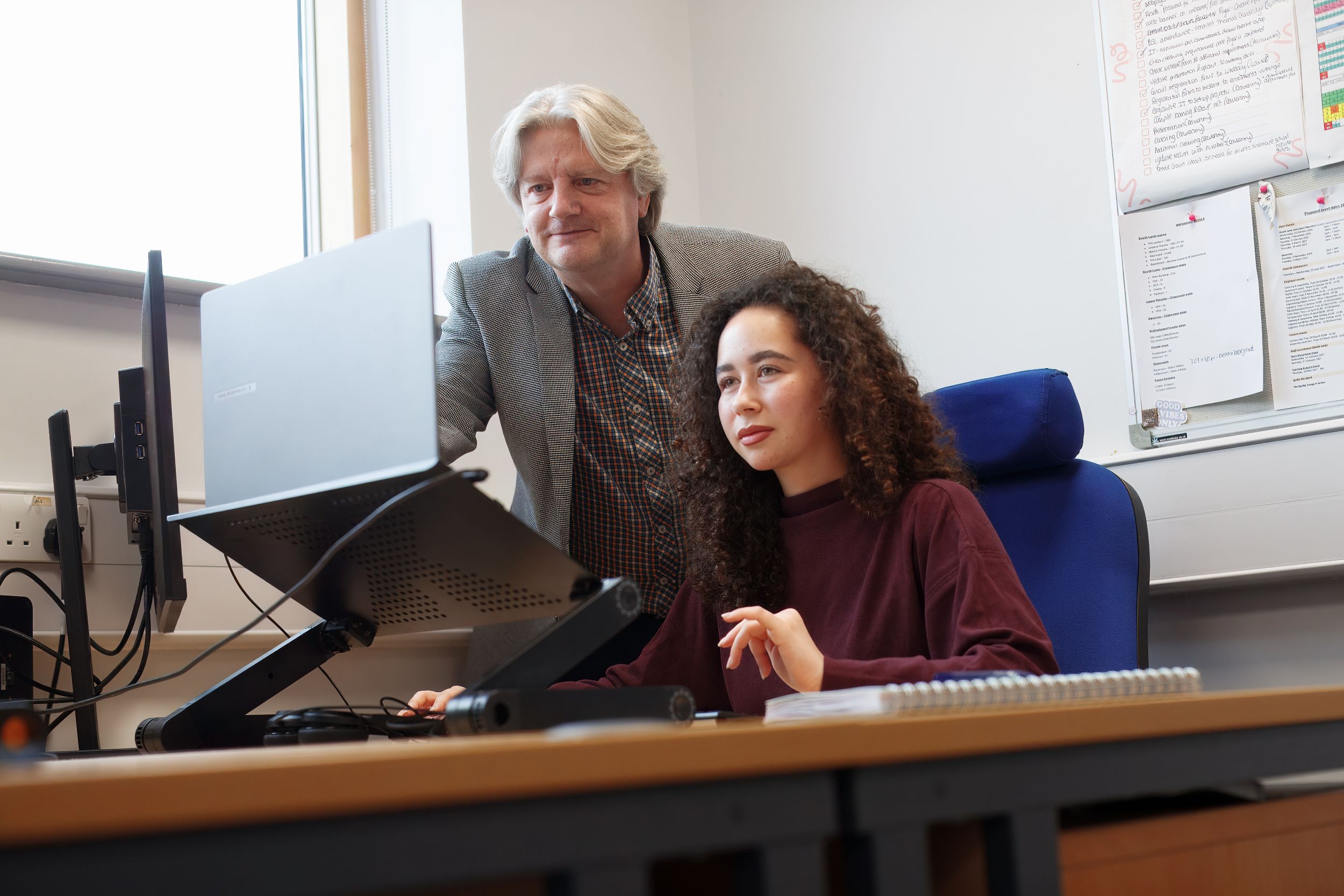 Two people looking at a laptop screen