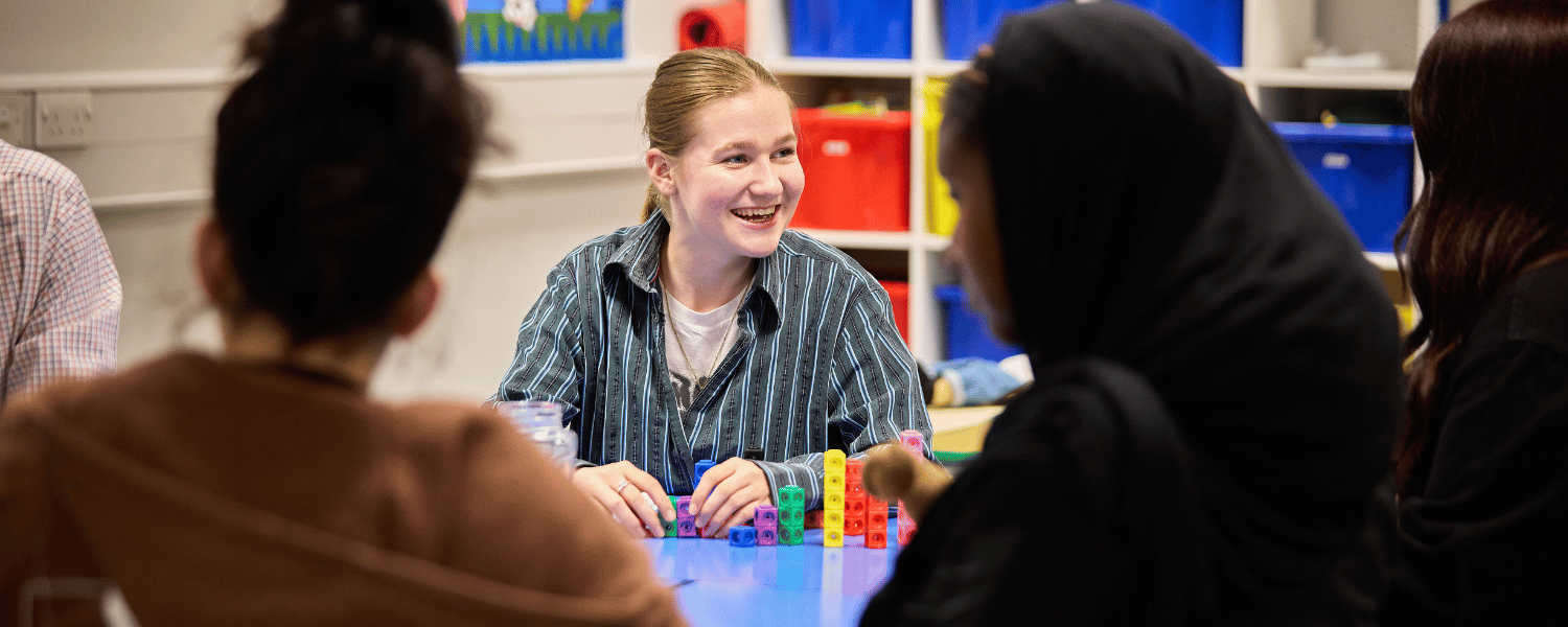 Image shows one student smiling to camera and three students with their backs to the camera. 