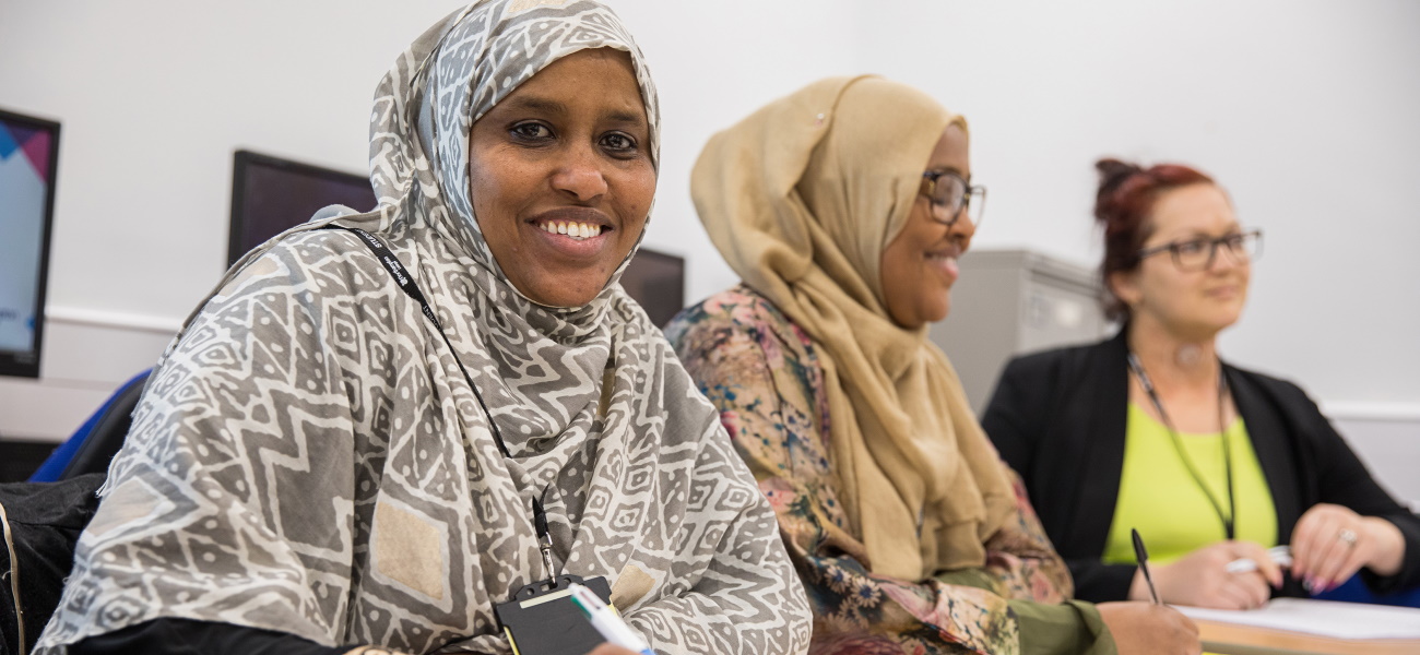 Adult students smiling in a lesson.