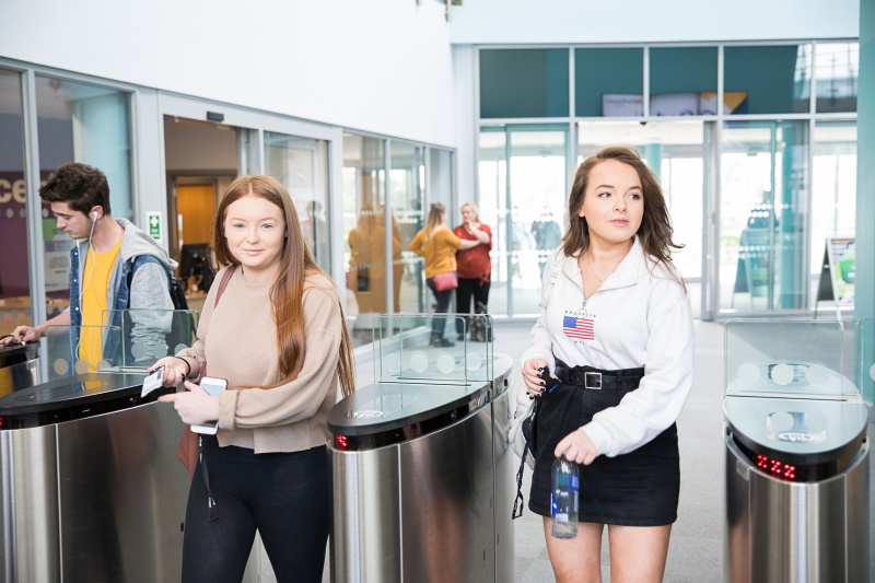 Two students use their ID cards to pass through the barriers at Booth Lane.