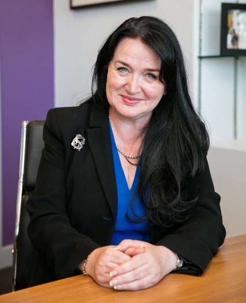 Northampton College Principal, Pat Brennan-Barrett, poses in her office, hands on her desk