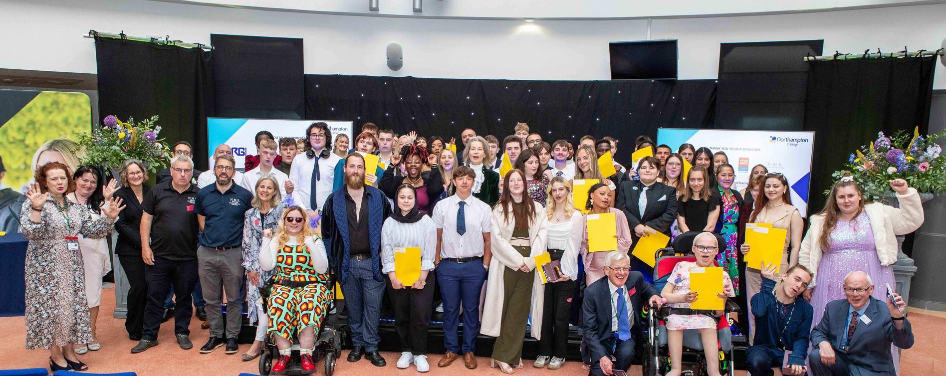 Student award winners pose on stage at awards ceremony.