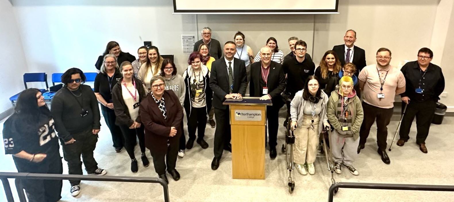 Photo shows staff and students posing in the Lecture Theatre with Chris Leggett.