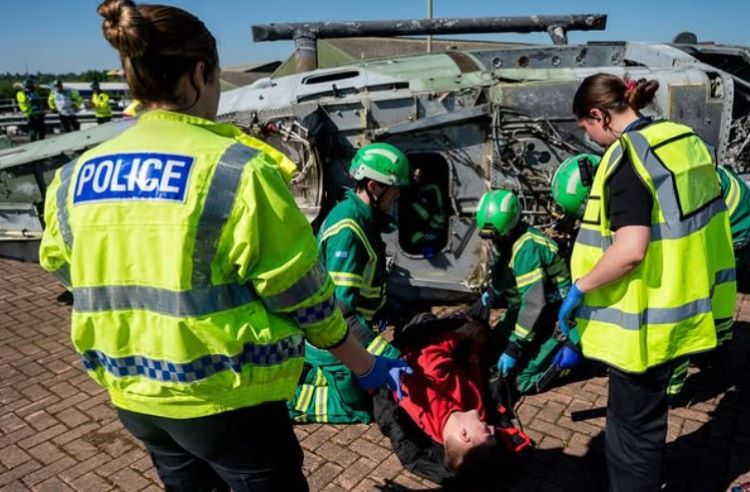 Photo shows students taking part in an emergency services exercise with local police and ambulance staff.