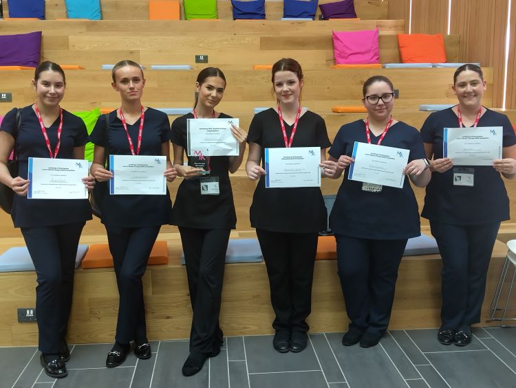 Photo shows students posing with their certificates of acheivement.
