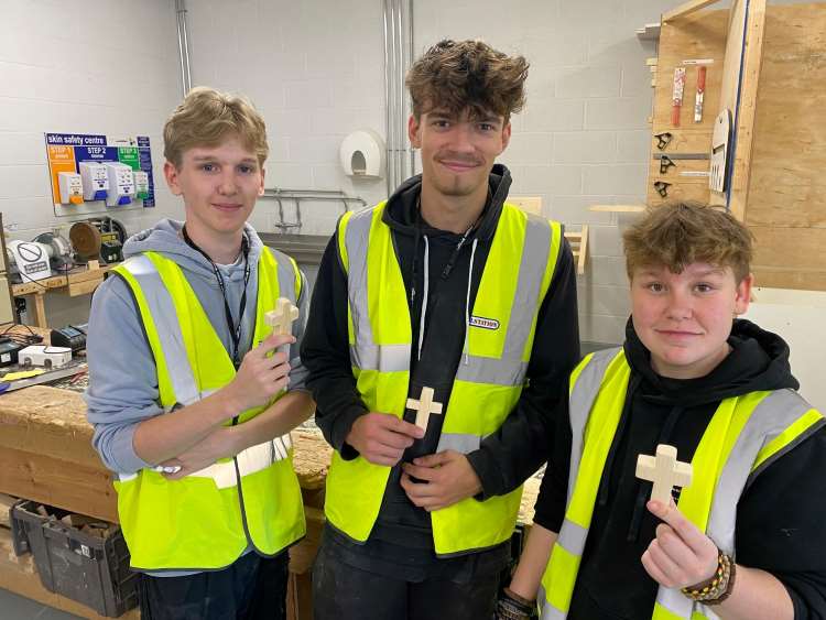 Construction students pose with the wooden crosses they are making for end-of-life patients, in partnership with The Lewis Foundation.