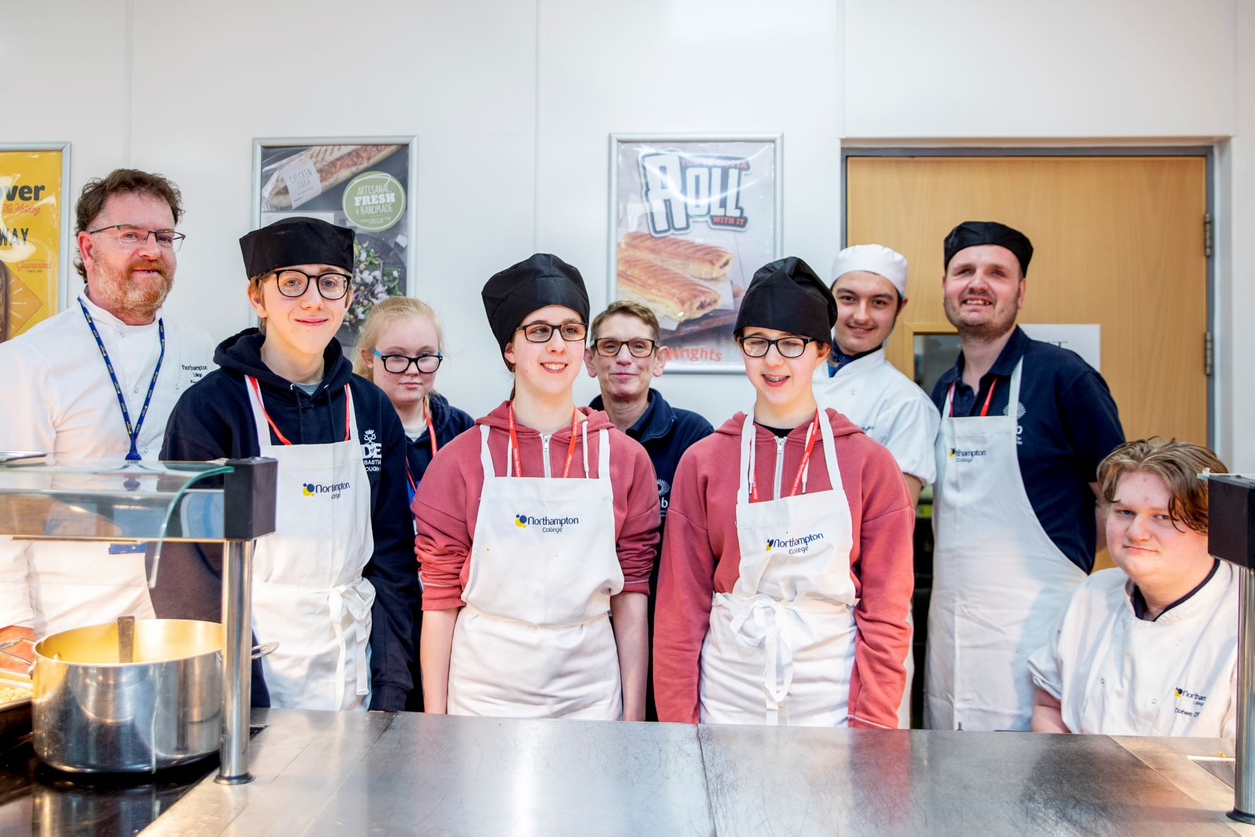 Northampton College catering students and NAB visitors posing in college kitchen