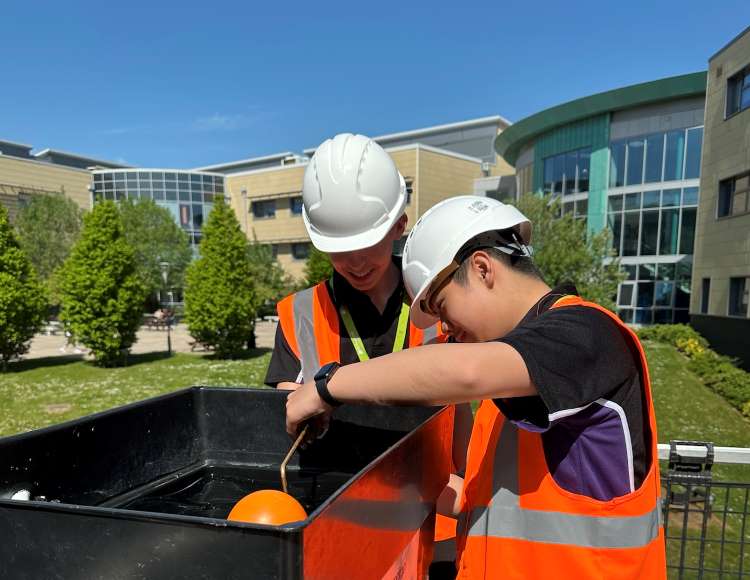 Photo shows two male students from Abbeyfield School working together on a float valve as part of The Big Rig challenge.