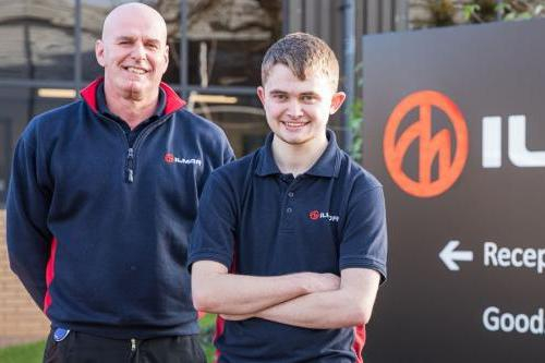 Employer from Ilmor Engineering poses outside main offices with male student.