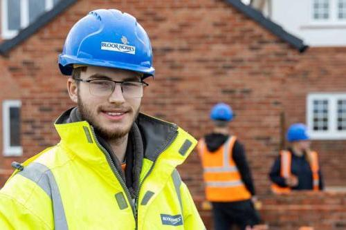 Male construction student poses on site.