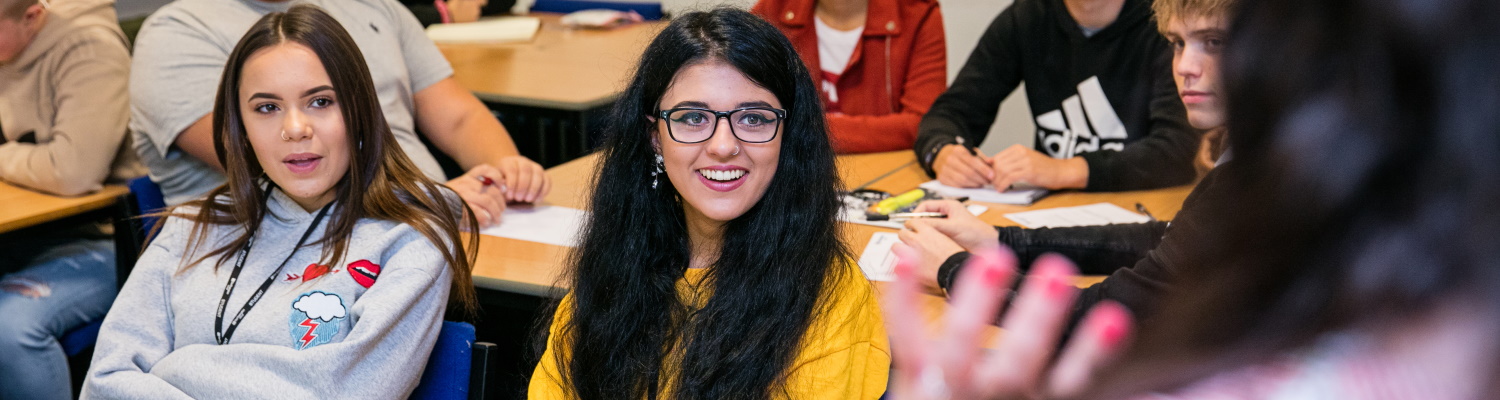 Student in a classroom smiling.